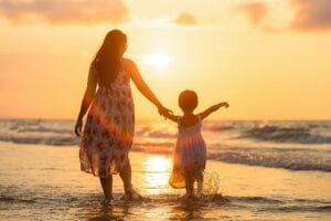 An image of mother and daughter in the sea to support article on how we should explain terrorism to our children