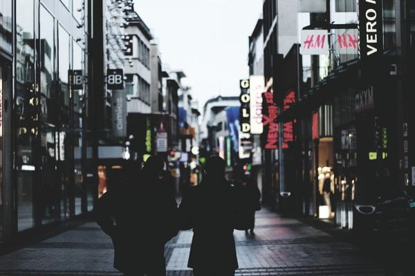 Two people walking down a high street