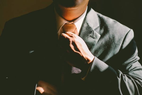 Close up of a man tightening his suit tie