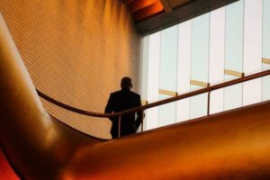 Suited man on balcony in corporate office building to support the advantages of being prepared in the workplace when it comes to business security