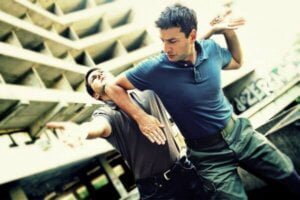 Two men fighting at work to highlight the how's of dealing with workplace threats