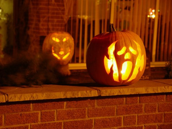 Two pumpkins outside a house