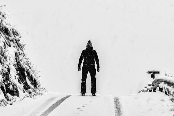 A man dressed in black standing in the snow