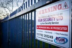 A RGM warning security sign located on a perimeter fence of a industrial unit