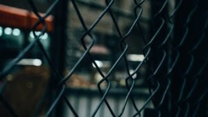 fence with a blurred building in its interior to illustrate perimeter security fencing