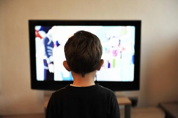 A little boy watching the TV