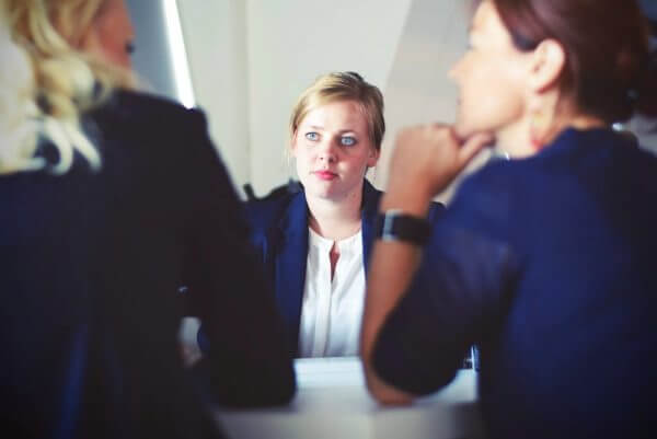 Employee sitting opposite two women