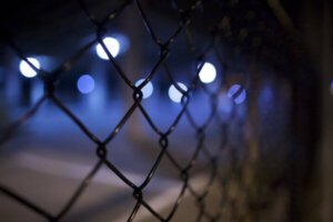 Steel wire perimeter security fencing of factory unit at night