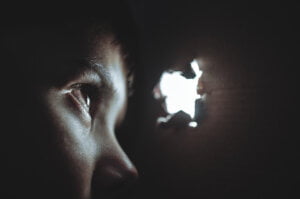 a child looking through a peephole to illustrate hidden threats to your business security that you need to know about