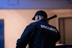 Security guard with torch doing night patrols around factory and recycling plant