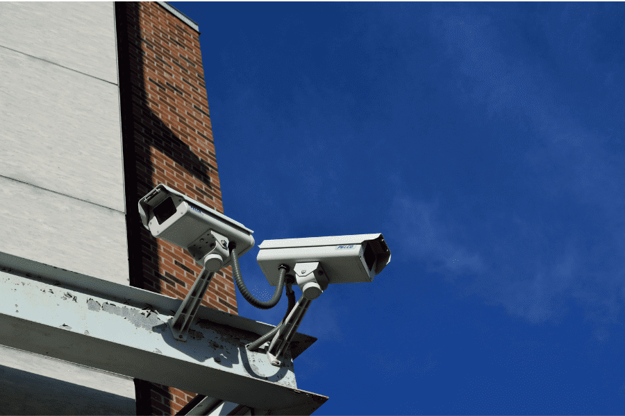 2 security cameras attached to office buildings