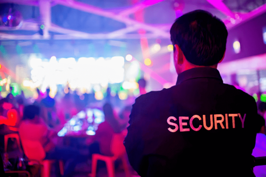 Security guard overlooking crowd in concert hall in Swansea