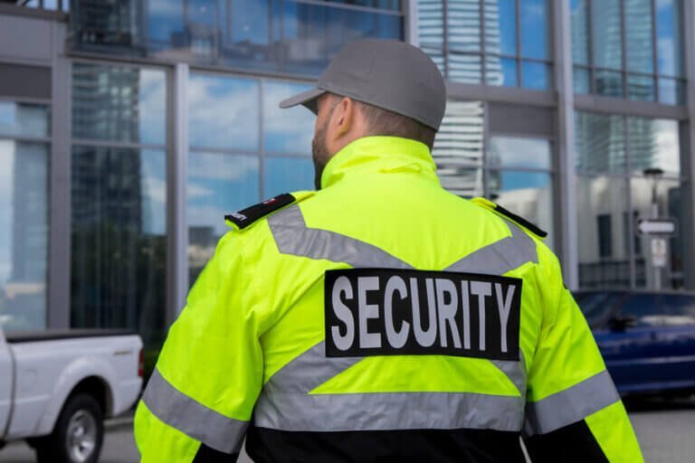 Manned Security Guard in Swansea South Wales on patrol wearing cap and high viz security jacket