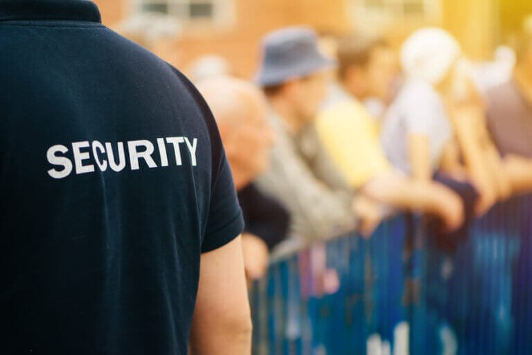 Manned security guard patrolling roadside and providing crowd control during street event in Swansea South Wales