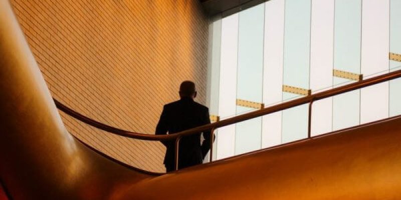 Suited man on balcony in corporate office building to support the advantages of being prepared in the workplace when it comes to business security