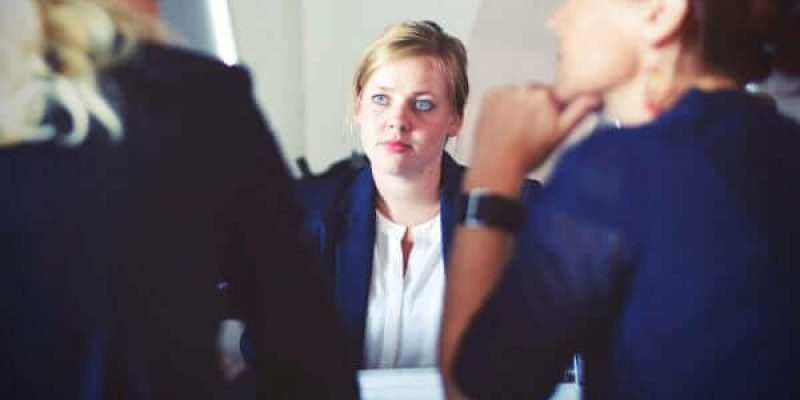 Employee sitting opposite two women to represent staff being one of the security risks for businesses