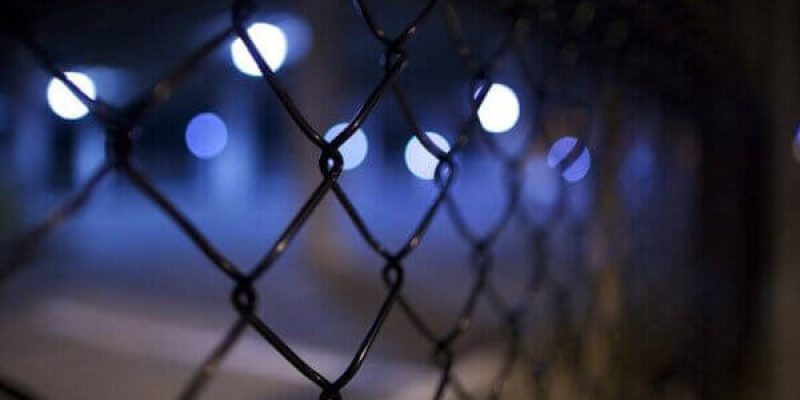 Steel wire perimeter security fencing of factory unit at night
