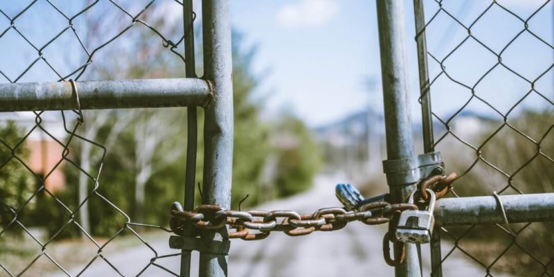 a gate that is locked with a chain lock to illustrate securely protecting a vacant premises
