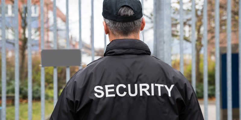 Security guard attending large security gate of university campus